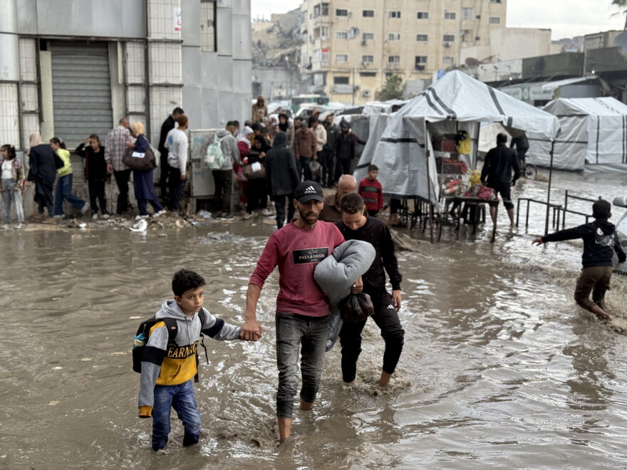 Un père et son fils traversent des rues inondées à Gaza-ville.