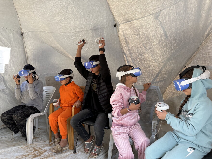 Des enfants utilisent des casques de réalité virtuelle à Al-Zuweida.