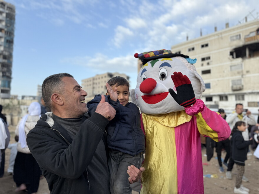 Un enfant sourit près d’un clown à Gaza-ville.
