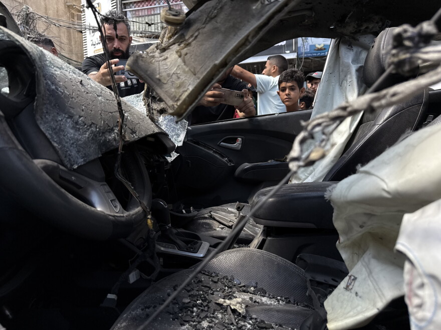 Un enfant regarde l’intérieur d’une voiture incendiée à Gaza-ville.